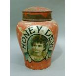 A pottery jar with painted tin domed cover, the baluster body transfer printed with a female