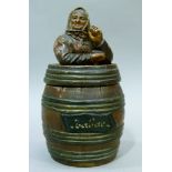 A glazed earthenware tobacco jar and cover modelled as a country woman wearing a head scarf and