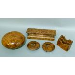 A set of Amboyna desk accessories including, pen tray with hinged lid, circular box and cover,