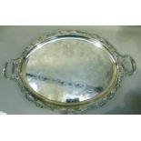 A late Victorian/Edwardian silver plated two handled tray of oval outline, the rim cast with C