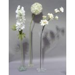 Three tall glass vases of waisted form and hexagonal bases; together with faux flowers