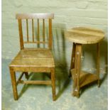 An Arts and Crafts oak table circular top above pierced supports joined by a triangular undertier,