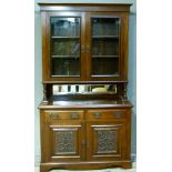 A Victorian walnut book case cupboard, having a moulded cornice above two glazed doors, the interior
