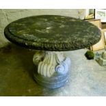 A large circular garden table the top with egg and dart moulded border on a scroll moulded base,