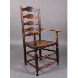A 19TH CENTURY ELM GRADUATED LADDER BACK ELBOW CHAIR with shaped flattened arms, boarded seat,