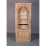 A PINE CORNER STANDING CUPBOARD of 18th century design, having a barrel arched open shelf