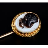 A 19TH CENTURY ONYX CAMEO AND DIAMOND TIE PIN in 18ct gold, the oval portrait of an African, the