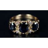 A SAPPHIRE AND DIAMOND RING the three graduated oval faceted sapphire claw set inline and