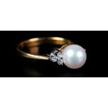 A CULTURED PEARL AND DIAMOND RING the 7mm pearl flanked by small brilliant cut diamonds in yellow