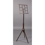 A WHEELDON'S PATENT STAINED BEECH ADJUSTABLE MUSIC STAND with tilting music rest and tapered stem,