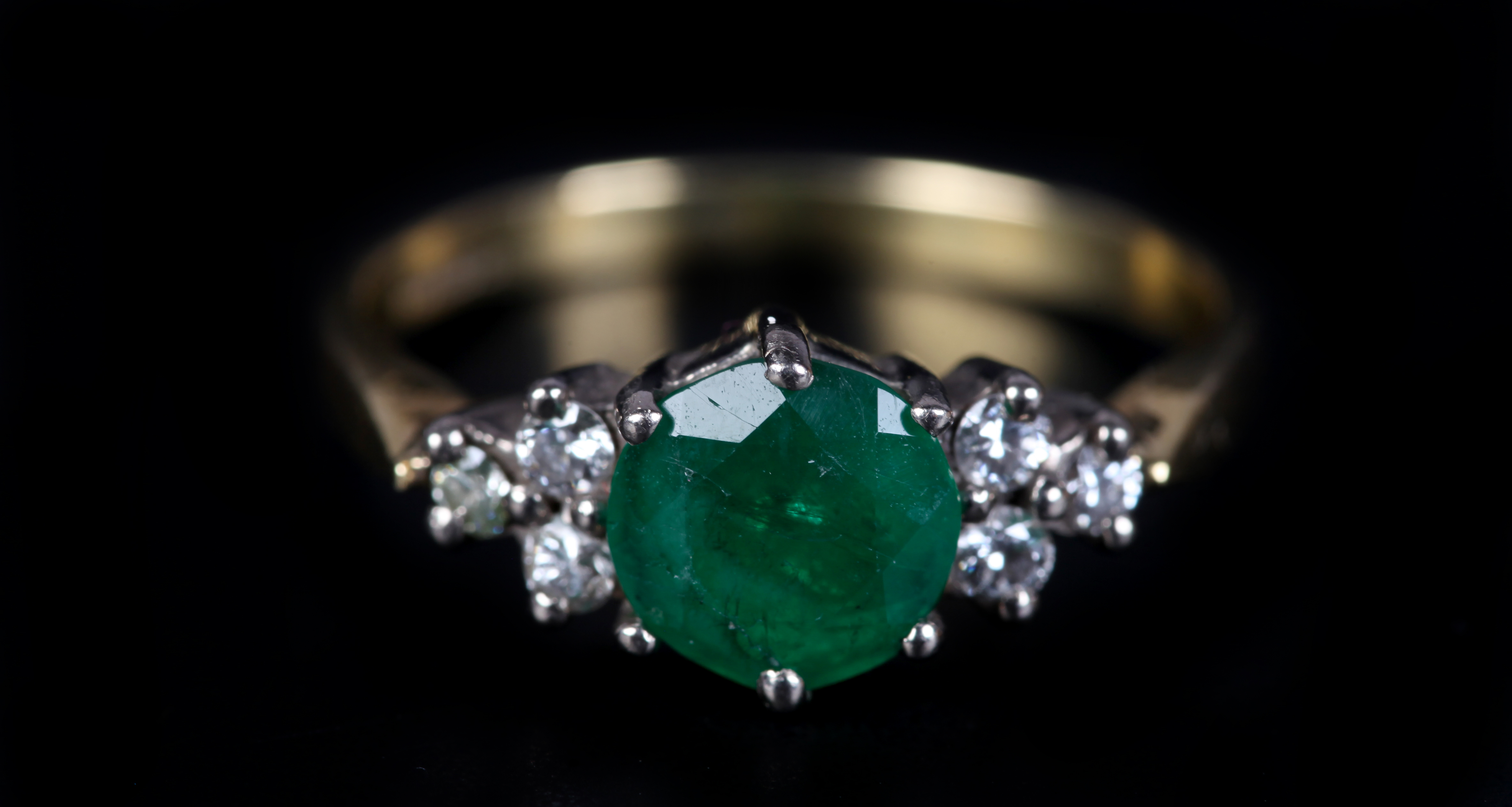 AN EMERALD AND DIAMOND RING in 18ct yellow and white gold, claw set to the centre with a circular