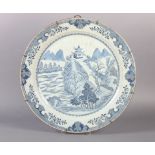 A CHINESE BLUE AND WHITE CIRCULAR CHARGER painted to the centre with an extensive mountainous