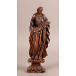 A 17TH CENTURY PINE FIGURE OF A SAINT, his left arm holding his cloak, his right arm raised, waisted