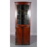 A 19TH CENTURY MAHOGANY BOW FRONT STANDING CORNER CUPBOARD, having a moulded cornice above a