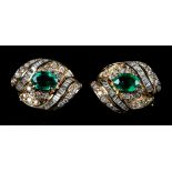 A PAIR OF EMERALD AND DIAMOND EARRINGS each claw set to the centre with an oval faceted emerald