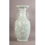 A CHINESE CELADON GLAZED BALUSTER TWO HANDLED VASE decorated overall in shallow relief, white