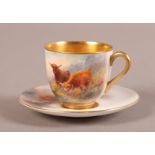 A ROYAL WORCESTER CUP AND SAUCER painted with highland cattle in a lake and mountain landscape,