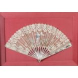 A 19TH CENTURY LACE FAN with pierced and gilt decorated mother of pearl guards, the fan worked