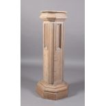 A 19TH CENTURY LIMED OAK PANELLED PEDESTAL with octagonal top above a geometric moulded collar,