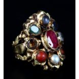 A CLUSTER RING collet set to the centre with an oval facetted ruby within a surround of emerald,