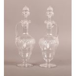 A PAIR OF EDWARDIAN CUT GLASS VINEGAR AND OIL EWERS, the inverted acorn shaped bodies with finely