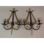 A PAIR OF BLACK JAPANNED AND BRASS TWO BRANCH GIRANDOLES with lyre shaped back plates with