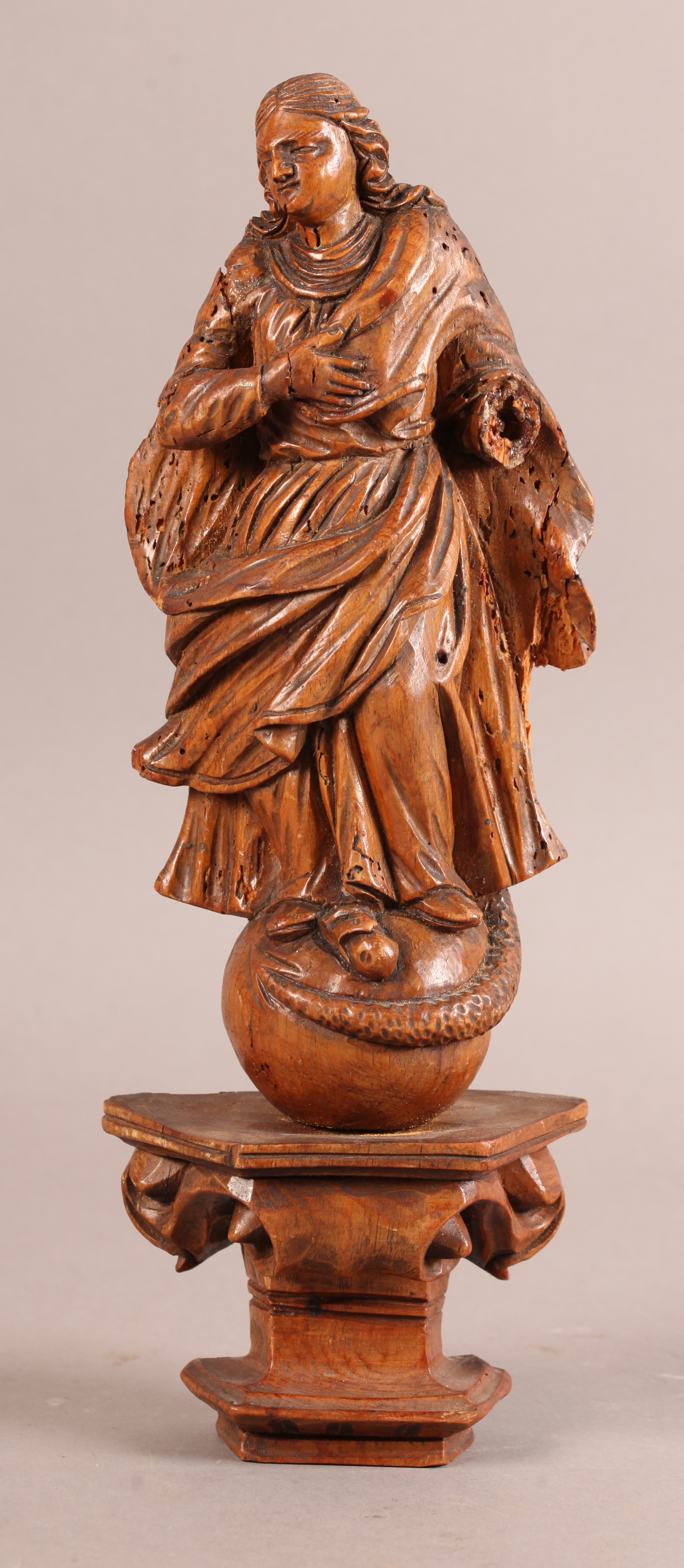 A 17TH CENTURY CARVED PINE FIGURE OF A SAINT with billowing cloak, his right arm across his chest, a