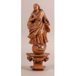 A 17TH CENTURY CARVED PINE FIGURE OF A SAINT with billowing cloak, his right arm across his chest, a