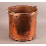 AN EARLY 20TH CENTURY COPPER COAL OR LOG BIN with swing handle and stud detailing, 33cm diameter x
