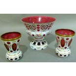 A WHITE AND CRANBERRY GLASS OVERLAY PEDESTAL BOWL, cut circles and lozenges to the body and