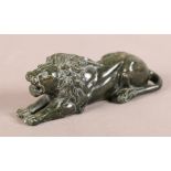 A GREEN SERPENTINE MODEL OF A RECUMBENT LION, carved mane and features, 12.5cm long