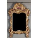 AN ITALIAN GILTWOOD WALL MIRROR in 18th century style, carved scrolls, shells and leafage around the