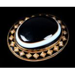 A VICTORIAN BANDED AGATE, ENAMEL AND PEARL BROOCH in 9ct gold, collet set to the centre with an oval