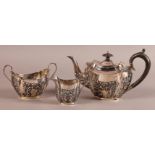 A VICTORIAN THREE PIECE SILVER TEA SERVICE in George III style with foliate embossed lower body