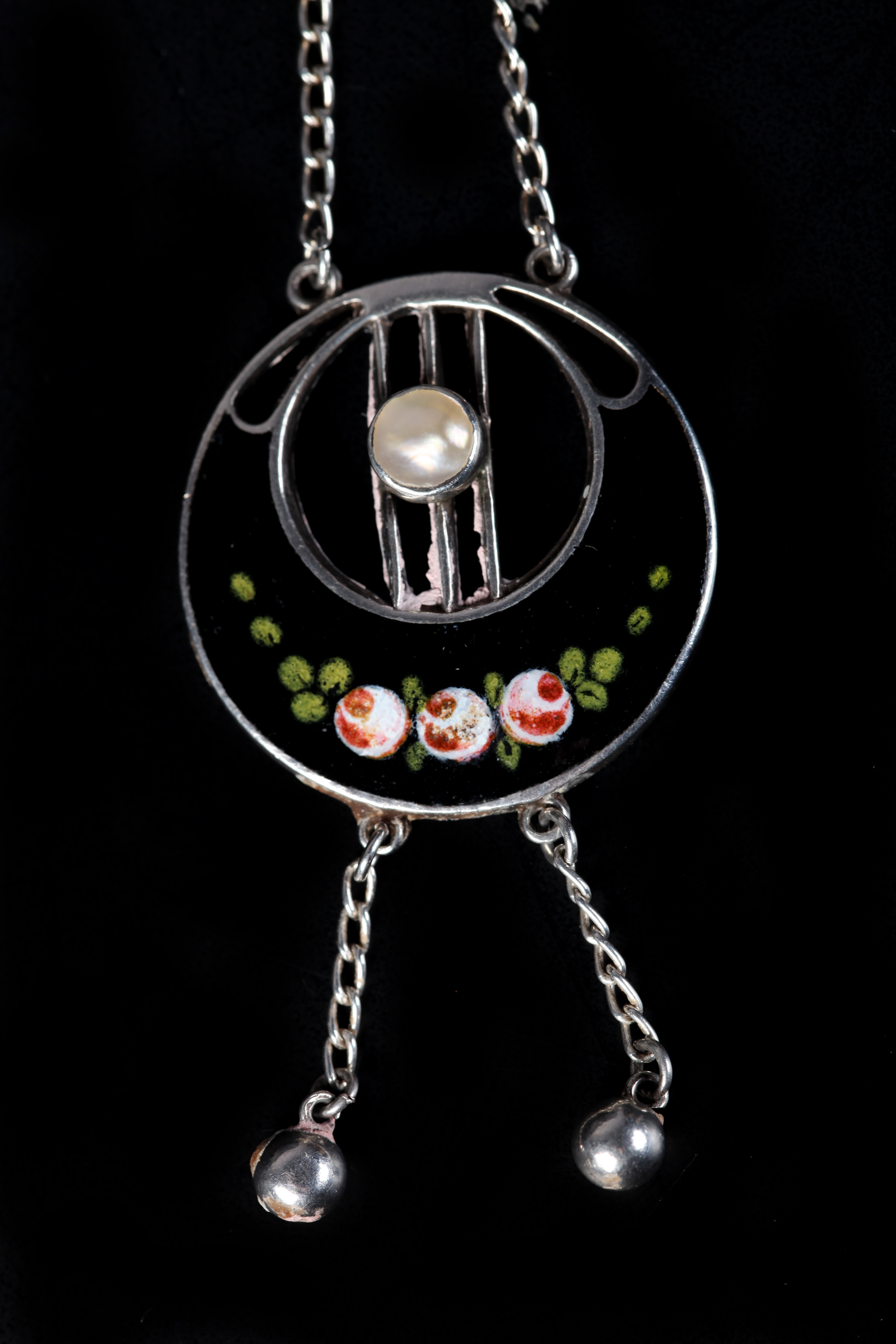 AN ART NOUVEAU PENDANT BY CHARLES HORNER in silver, collet set with a blister pearl within a pierced