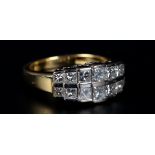 A DIAMOND RING in 18ct yellow and white gold, the graduated princess cut stone channel set in two