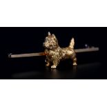 AN EDWARD VII SCOTTIE (CAIRN TERRIER) BROOCH in 15ct gold, the alert dog in full relief with