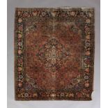 A CAUCASIAN RUG, the fox red field with dark blue lozenge medallion and spandrels, filled with