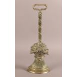 AN EARLY 19TH CENTURY BRASS DOORSTOP of wheatsheaf design with loop handle, 41cm high