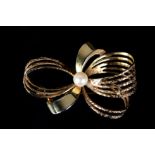 A CULTURED PEARL BOW BROOCH in 9ct gold, the 5mm set to the centre of a plain and textured ribbon
