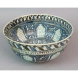 A 17TH CENTURY PERSIAN POTTERY CIRCULAR BOWL decorated in blues and blacks with a band of arches