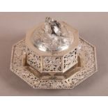 A CHINESE WHITE METAL TWO HANDLED BOX, COVER AND STAND, of octagonal form with pierced decoration