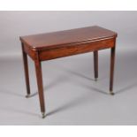 A LATE GEORGE III MAHOGANY TEA TABLE inlaid with ebonised stringing, rectangular fold over top