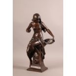 A FRENCH BRONZED SPELTER FIGURE of a lightly clad female seated on a pillar, she holds an oval