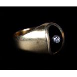 A GENTLEMAN'S ONYX AND DIAMOND SET SIGNET RING, the small brilliant cut diamond collet set to the