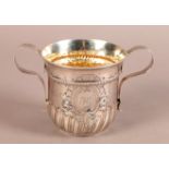 AN EARLY GEORGE III SILVER TWO HANDLED CUP of lobed fluted form at the base, 'rope' girdle and