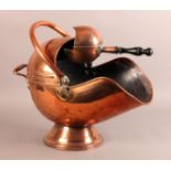 A VICTORIAN COPPER COAL SCUTTLE of helmet shape, spreading circular foot, swing loop handle;