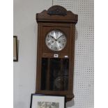 A Polished Oak Pendulum Wall Clock