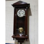 A Mahogany Encased Pendulum Wall Clock With Circular Dial