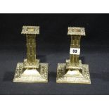 A Pair Of Square Based Brass Column Candlesticks